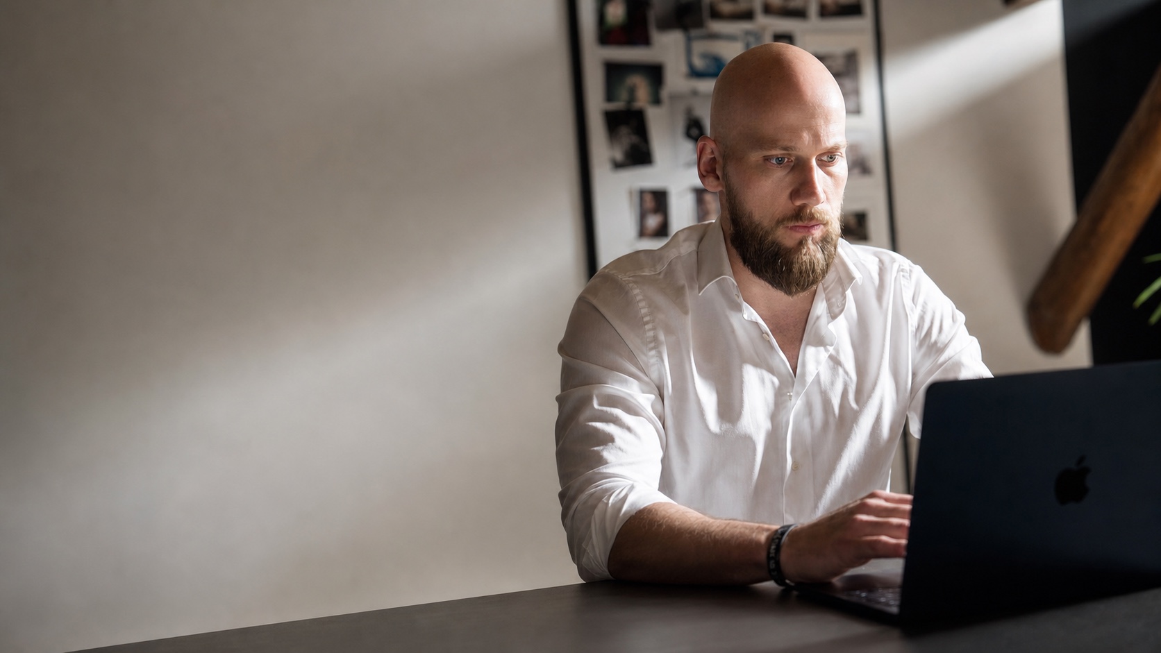 Dennis Kolwey im weißen Hemd, konzentriert bei der Arbeit am Laptop – KI-bearbeitetes Motiv